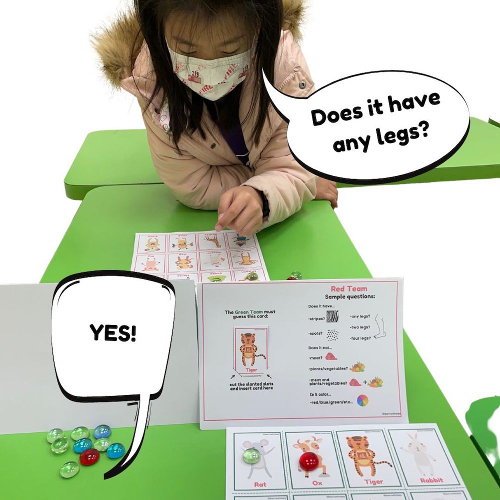 young girl on a desk playing a Chinese New Year Guess Who game